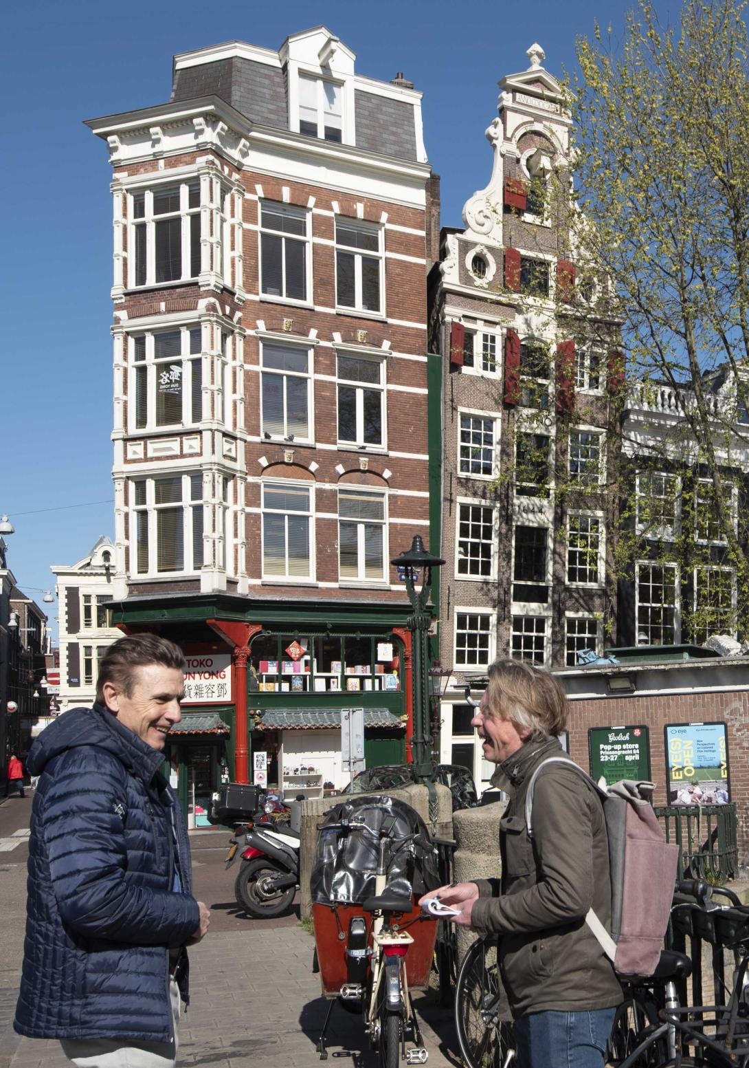 Stadsgoeddirecteur Ronald Wiggers in gesprek. Het monumentale gebouw Geldersekade 82 is op de achtergrond te zien